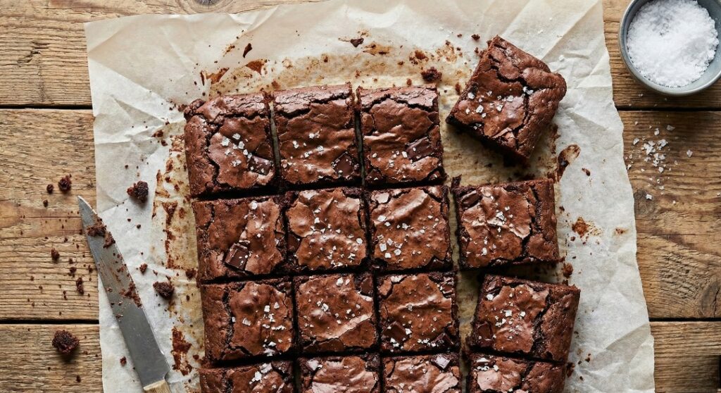 Homemade The Ultimate Fudgy Brownie Recipe: A Deep Dive into Chocolate Perfection with a crinkly top and sea salt on a baking sheet - Good Food Remedies.
